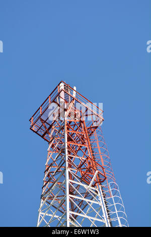 Telekommunikation-Mast mit Mikrowellenverbindung und TV-Sendeantennen auf blauen Himmel. Stockfoto