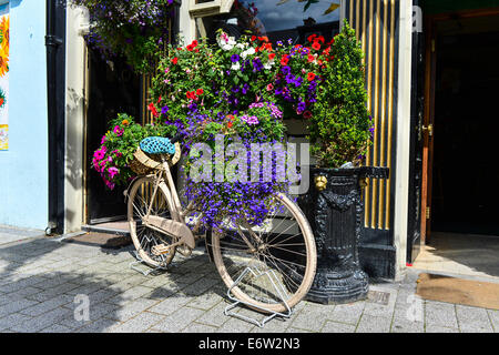 Fahrrad in Blumen außerhalb Jean O'Flahertys traditionellen irischen Pub, Buncrana, County Donegal, Irland bedeckt. Stockfoto