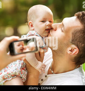 Familie mit Baby im Park nehmen Selfie per Handy Stockfoto