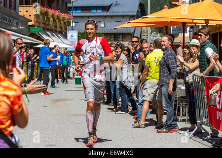 Französische ultra Läufer François D'Haene tritt Chamonix Stadtzentrum auf seinem Weg zum UTMB Sieg. Das Rennen führt durch 3 Alpenländer (Frankreich, Schweiz und Italien), über viele hohe Pässe für insgesamt 163km laufen und 9600m Höhe Gewinn insgesamt während der Umrundung des Mont Blanc-Massivs. Das Rennen wird in Teilautonomie mit nur ein paar Haltestellen für Futter und Wasser durchgeführt. Es ist für 2 Nächte und 2 Tage laufen. Die ersten Läufer erreichte weniger als 21 Stunden Chamonix. Stockfoto