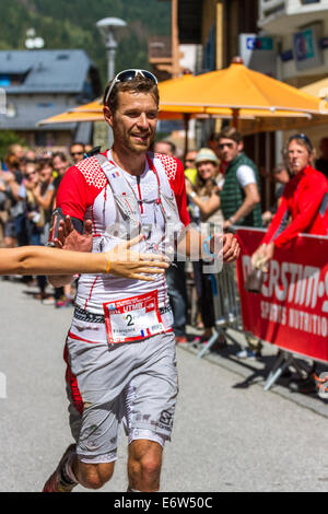 Französische ultra Läufer François D'Haene tritt Chamonix Stadtzentrum auf seinem Weg zum UTMB Sieg. Das Rennen führt durch 3 Alpenländer (Frankreich, Schweiz und Italien), über viele hohe Pässe für insgesamt 163km laufen und 9600m Höhe Gewinn insgesamt während der Umrundung des Mont Blanc-Massivs. Das Rennen wird in Teilautonomie mit nur ein paar Haltestellen für Futter und Wasser durchgeführt. Es ist für 2 Nächte und 2 Tage laufen. Die ersten Läufer erreichte weniger als 21 Stunden Chamonix. Stockfoto