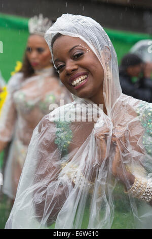 Samba-Tänzer eingewickelt in Plastikfolie aus London Schule von Samba an einem regnerischen Notting Hill Carnival parade Stockfoto