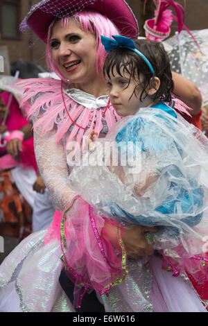 Darsteller mit einem Kind von Paraiso Schule von Samba an einem regnerischen Notting Hill Carnival parade Stockfoto