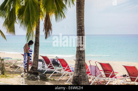 Eine Kaukasische Frau mit Tätowierungen trocknet nach einem Bad im karibischen Meer auf der Insel St. Croix, U.s. Virgin Islands. Stockfoto