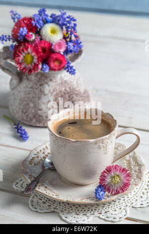 Blumen-Gänseblümchen und Tasse Kaffee Stockfoto