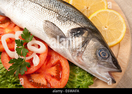 Frisch Bass Fisch mit Gemüse auf Holzbrett. Stockfoto