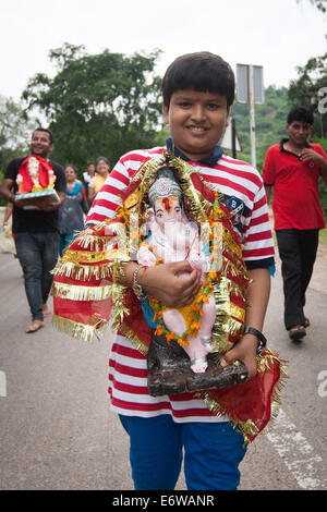 Jaipur, Indien. 31. August 2014. Ein Junge trägt die Statue des elefantenköpfigen Gottes Ganesh in Jaipur, Rajasthan Indien, 31. August 2014. Elefanten gelten als heilige Tiere in Indien, denn sie weithin als Transport-Werkzeuge seit der Antike verwendet wurden. Ganesh Chaturthi Festival feiert man in Indien als der Geburtstag der elefantenköpfige hinduistische Gott Ganesha, die weit von den Hindus als Gott der Weisheit, Wohlstand und Glück verehrt wird. Elefanten in Indien dienen heute hauptsächlich für touristische Attraktion. Bildnachweis: Xinhua/Alamy Live-Nachrichten Stockfoto