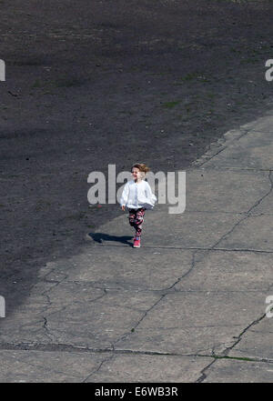 (140901)--FRANKFURT (Deutschland), 1. September 2014 (Xinhua)--ein Mädchen am Standort des ehemaligen Sachsenhausen Nazi-Konzentrationslager Oranienburg bei Berlin, Deutschland, am 21. August 2014 läuft. KZ Sachsenhausen Nazi wurde in Oranienburg ca. 35 km nördlich von Berlin im Jahre 1936 errichtet und etwa 220.000 Menschen zwischen 1936 und 1945 inhaftiert. Der Ort diente nun als Gedenkstätte und Museum über die Geschichte in der authentischen Umgebung, darunter die Reste von Gebäuden und anderen Relikten des Lagers zu lernen. (Xinhua/Luo Huanhuan) Stockfoto