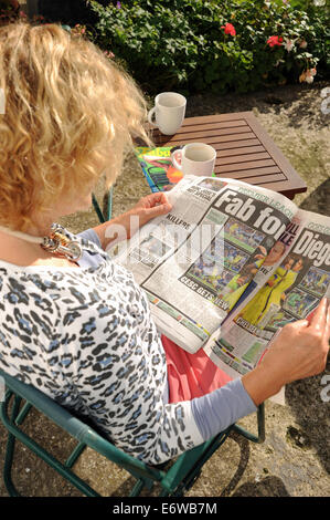 Frau im Garten die Sonne am Sonntag rot Top Boulevardzeitung UK lesen Stockfoto