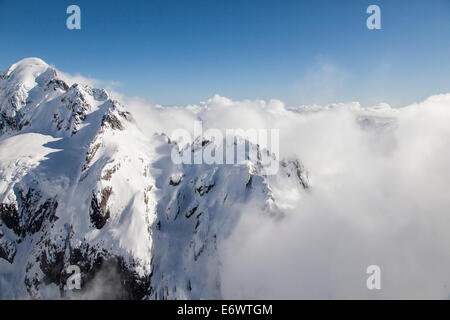 Helikopter-Rundflug über schneebedeckte Berge mit niedrigen Wolken, Bryneira Range, Südalpen, Südinsel, Neuseeland Stockfoto