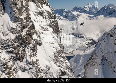 Helikopter-Rundflug durch eine Schlucht in verschneiten Bergen, Südalpen, Südinsel, Neuseeland Stockfoto