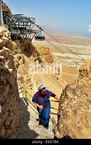 Frau geht auf Masada byzantinischen Westtor mit Seilbahn Überschrift unten auf Hintergrund, Israel. Stockfoto