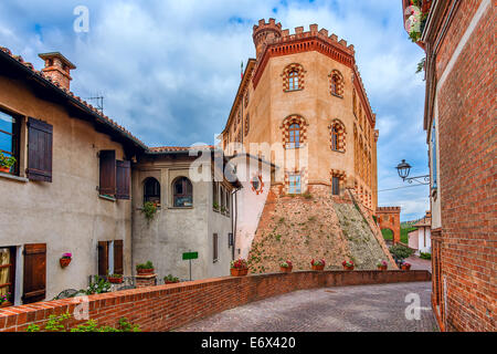 Schmalen gepflasterten Straße zwischen alten Häusern und mittelalterliche Burg in der Stadt Barolo im Piemont, Norditalien. Stockfoto