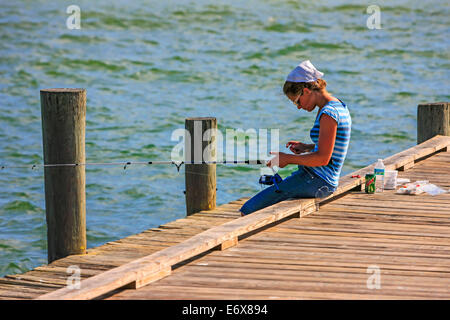 Eine junge amische Frau Fische an Anna Maria Pier in Bradenton FL Stockfoto