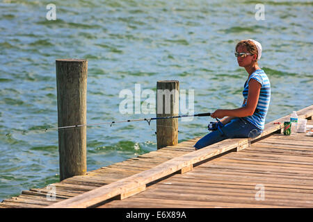 Eine junge amische Frau Fische an Anna Maria Pier in Bradenton FL Stockfoto