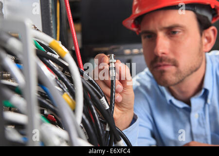 Netzwerkingenieur mit BNC-Kabel-Verbindung am Patch-panel Stockfoto