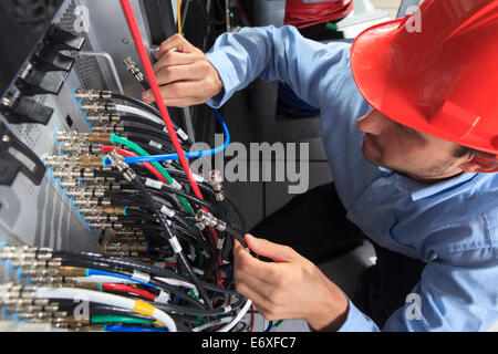 Netzwerkingenieur mit BNC-Kabel-Verbindung am Patch-panel Stockfoto