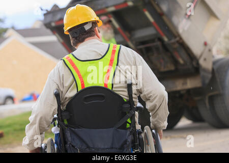 Bauleiter mit Spinal Cord Injury beobachten Muldenkipper Stockfoto