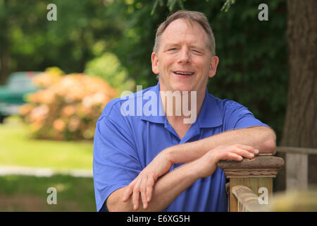 Menschen mit zerebraler Lähmung und Legasthenie entspannend auf seinem Zaun Stockfoto