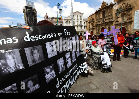 La Paz, Bolivien, 1. September 2014. Eine Aktivistin für Frauenrechte hält ein schwarzes Plakat mit den Fotos und Namen der Opfer von Frauenmorden auf der Plaza San Francisco während einer Demonstration, um gegen Gewalt gegen Frauen zu protestieren. Laut einem Bericht DER WHO vom Januar 2013 ist Bolivien das Land mit der höchsten Gewaltrate gegen Frauen in Lateinamerika, seit 2006 gab es 453 Fälle von Frauenmord. Ein Teil der Kirche von San Francisco befindet sich im Hintergrund. Quelle: James Brunker / Alamy Live News Stockfoto