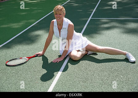 Attraktive weibliche Tennisspieler auf dem Platz gefallen ist vom Boden aufstehen. Stockfoto