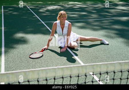 Attraktive weibliche Tennisspieler auf dem Platz gefallen ist vom Boden aufstehen. Stockfoto