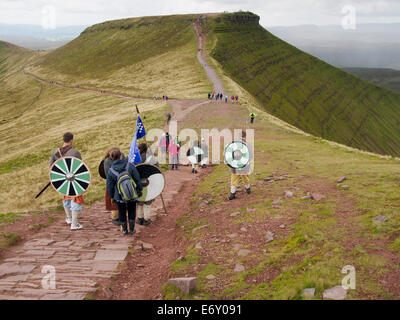 Bergwandern auf die Brecon Beacons. Eine Gruppe von Nächstenliebe Wanderer im keltischen Kleid auf dem Fußweg von Pen y Fan mit Mais Du voran Stockfoto