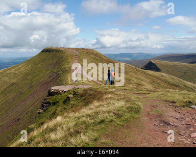 Bergwandern auf die Brecon Beacons. Wanderer am Gipfel des Mais Du freuen über den Col auf die Gipfel des Pen y Fan. Stockfoto