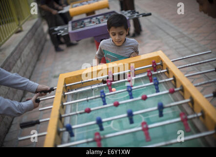 Teheran, Iran. 1. September 2014. Zwei Männer spielen Tischfußball als kleiner Jungenuhr in Teherans Künstler Park. Bildnachweis: Morteza Nikoubazl/ZUMA Draht/Alamy Live-Nachrichten Stockfoto