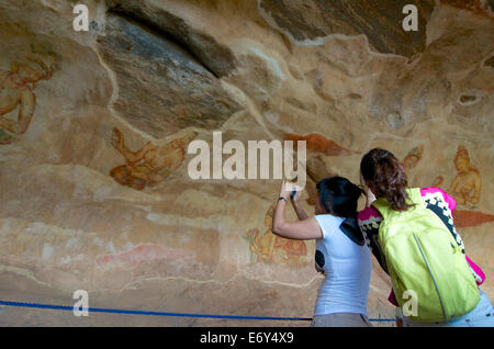 Asiatische Touristen fotografieren die Sigiriya Mamsells Fresken auf dem Felsen Matale Distict, kulturellen Triangel, Sigiriya, Sri Stockfoto