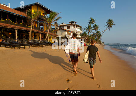 Zwei männliche Surfer mit ihren Brettern am Strand von Hikkaduwa, Sri Lanka Westküste. Süd-Asien Stockfoto