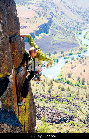 Mark Huth Klettern im Bereich Forelle-Nebenfluß des central Oregon mit dem Deschutes River hinter Stockfoto