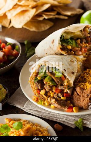 Hausgemachte Riesen Rindfleisch-Burrito mit Salsa Salat und Reis Stockfoto