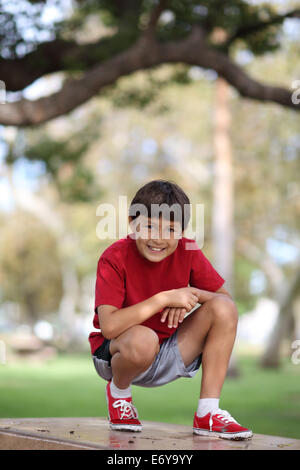 Kleiner Junge entspannen im Park auf einem Tisch Stockfoto