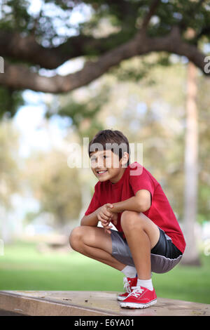 Kleiner Junge entspannen im Park auf einem Tisch Stockfoto