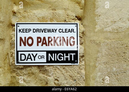 Kein Parkplatz Zeichen ziert eine Kalksteinwand in einer Wohn Gasse in Fremantle, Western Australia, Australien. Stockfoto