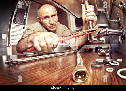 lächelnde senior Klempner bei der Arbeit Stockfoto