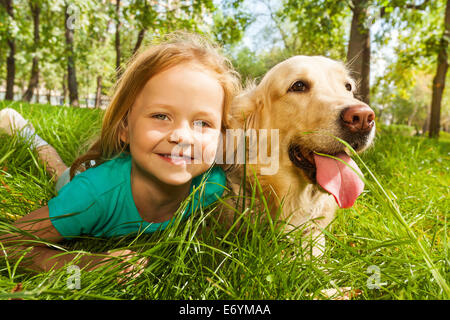 Kleines blondes Mädchen mit ihrem Retriever Hund Stockfoto