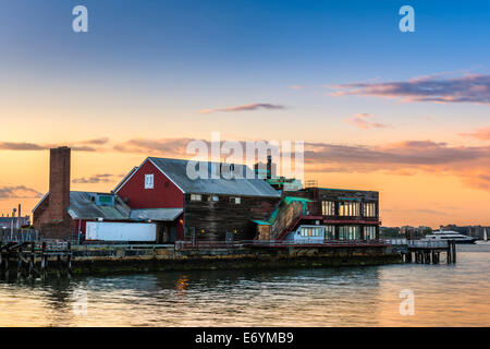 Eines der Gebäude gegenüber dem Hafen Spaziergang bei Sonnenuntergang entlang der Seaport District von Boston, Massachusetts - USA. Stockfoto