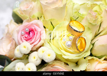 Goldene Hochzeit Ringe auf den Strauß Rosen Stockfoto