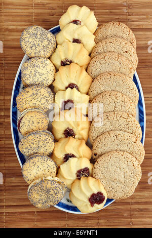 Süße Butterkekse mit Mohn und Marmelade auf einem Holzbrett Stockfoto