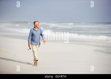 Ältere Mann zu Fuß am Strand Stockfoto