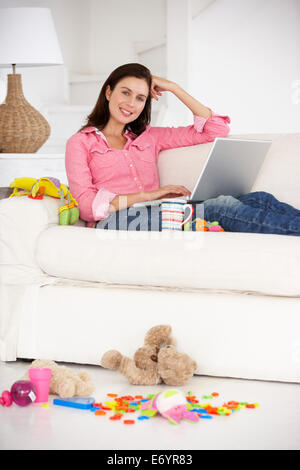 Beschäftigt Mutter auf laptop Stockfoto
