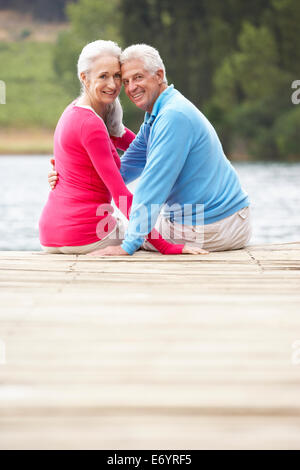 Romantische älteres Paar sitzt auf einem Steg Stockfoto