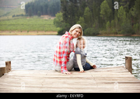 Mutter und Tochter sitzen auf einem Steg Stockfoto