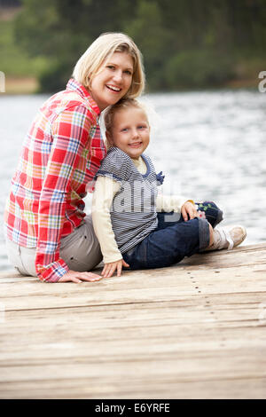 Mutter und Tochter sitzen auf einem Steg Stockfoto