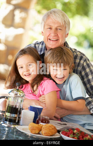 Mitte Alter Frühstück Mann und Enkel Essen im freien Stockfoto