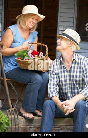 Älteres Paar, sitzen auf der Veranda mit Blumen Stockfoto