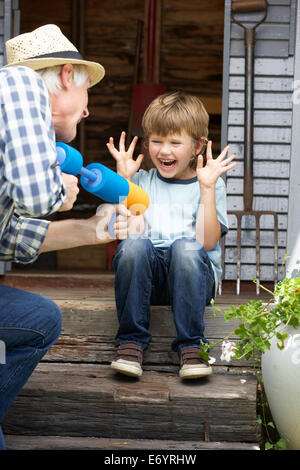 Großvater und Enkel spielen im Garten Stockfoto