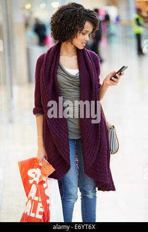 Frau im Einkaufszentrum mit Handy Stockfoto